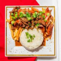 Lomo Saltado De Carne · Steak sautéed with onions, tomatoes, and soy sauce with French fries and white rice.