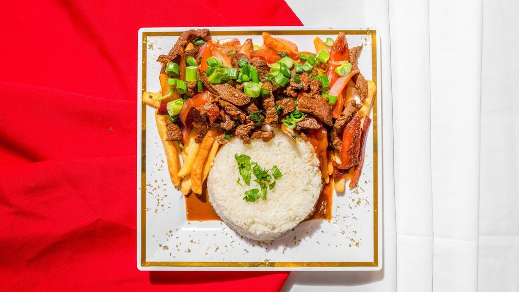Lomo Saltado De Carne · Steak sautéed with onions, tomatoes, and soy sauce with French fries and white rice.