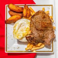 Bistec A La Pobre · Fried steak served with white rice, sweet plantain, French fries, and fried egg.