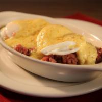 Hash Benedict · Two poached eggs, homemade corned beef hash, american cheese with hollandaise