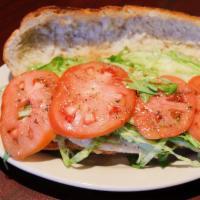 Grilled Chicken Hero · Grilled, seasoned chicken cutlets with lettuce, tomato and Italian dressing on a hero roll.