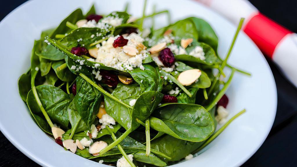 Baby Spinach & Gorgonzola · Cranberries, toasted almonds, champagne vinaigrette.