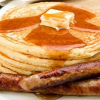 Pork Sausage Buttermilk Pancakes · 3 perfectly fluffy pancakes topped with pork sausage served with a side of butter and syrup.