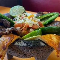 Discada Al Molcajete · Hot and spicy. Grilled chicken and steak, cooked with onions, jalapeño, green sauce, cheese,...