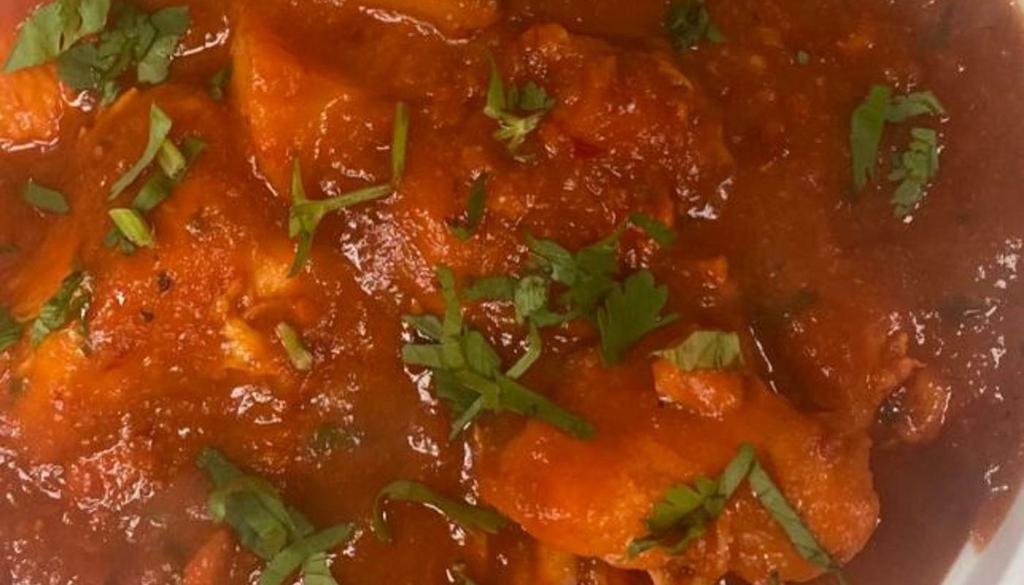 Chicken Vindaloo · Chicken in a hot and sour tangy tomato curry spicy sauce with potatoes.
