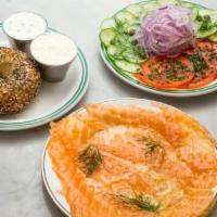 House Salmon · Served with bagel, tomato, cucumber, onions, and capers.