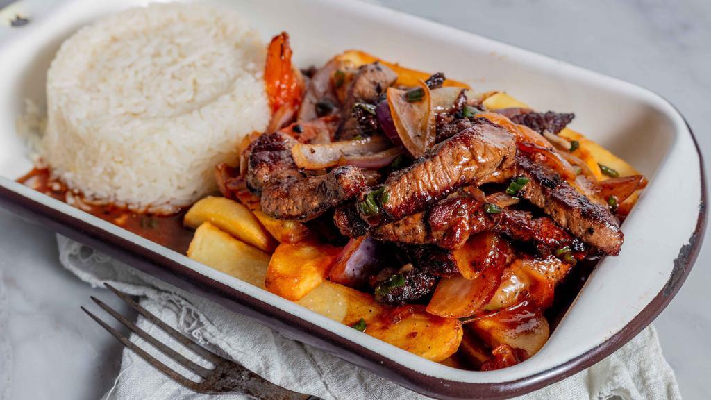 Lomo Saltado · Marinated beef steak stir fry with onions , tomato French fries , served with yellow rice or white .