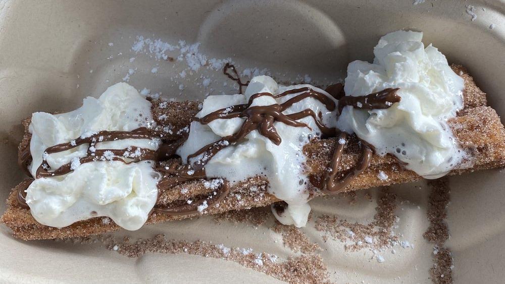 Churro · Jumbo churro rolled in sugar and cinnamon, topped with nutella and whipped cream.