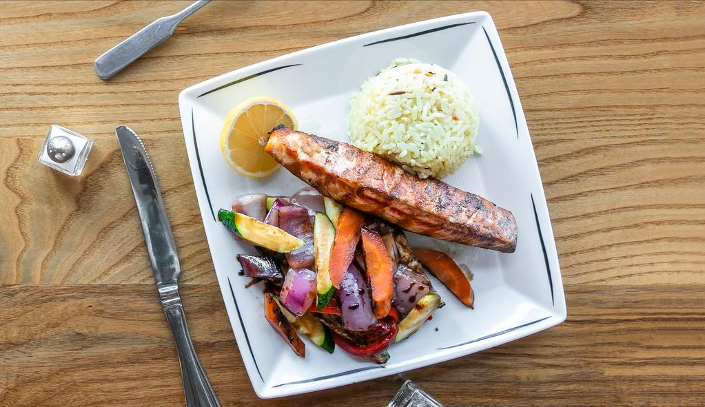 Solomos Sharas · A grilled salmon fillet served with grilled vegetables and rice with olive oil-lemon sauce.