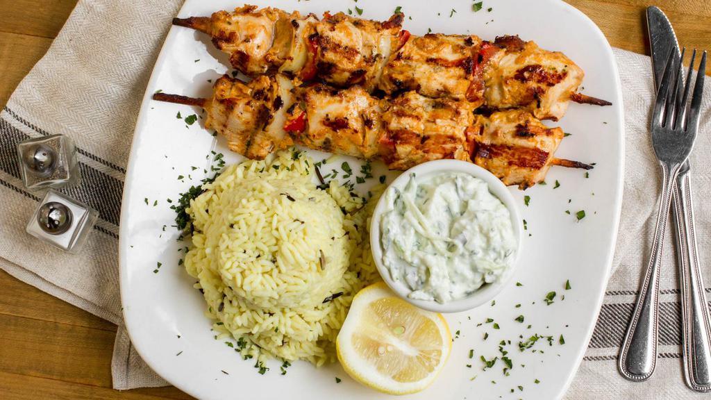 Chicken Souvlaki · Grilled marinated chicken fillet with onions and pepper on a stick served with tzatziki sauce and rice.