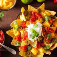 Chicken Nachos · Savory chicken with sautéed onion and peppers and topped with melted cheese loaded onto cris...