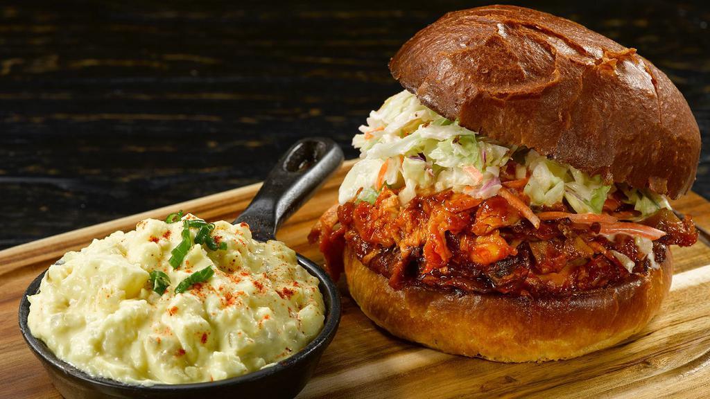 Low Country Pulled Chicken Sandwich · topped with coleslaw; savory moist pulled chicken served with a side of Grandma Sarah “Boobie’s” potato salad.