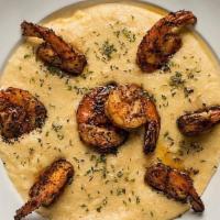 Shrimp And Grits · Fiery blackened shrimp on sharp cheddar grits with a green onion oil. |