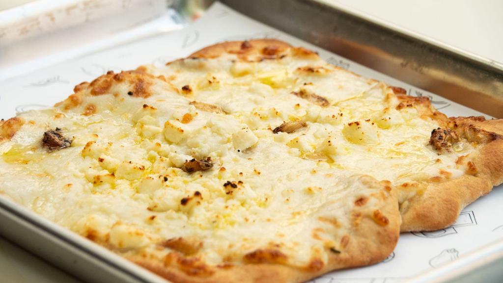 Tropical White Pizza · Alfredo Sauce, mozzarella, feta cheese and roasted garlic with extra virgin olive oil. Made with fresh 100% whole wheat naan crust.