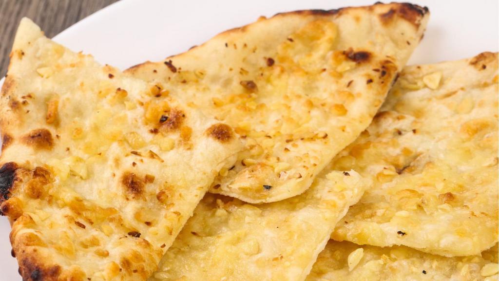 Garlic Nan · Teardrop shaped traditional punjabi white bread, baked in the tandoor with garlic.