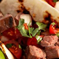 Steak Taco · 3 pieces tacos served with onions, and cilantro, reddish, lime, and choice of green or red s...