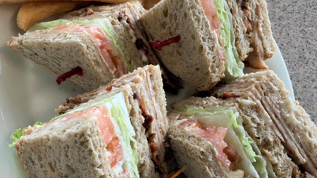 Turkey Club · oven-roasted turkey breast piled high with crisp bacon, lettuce, tomato and mayo on triple decker toast of your choice