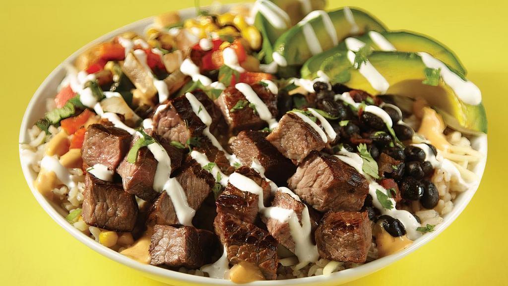 Spicy Steakhouse Bowl · Carne asada steak, chipotle queso, black beans, white rice, . jack cheese, sautéed peppers & onions, roasted corn & . avocado all wrapped in a house-made jalapeño tortilla. This . ain’t your daddy’s steakhouse.