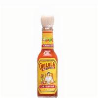 Side Of Hot Sauce · A small bottle of Cholula Hot Sauce.