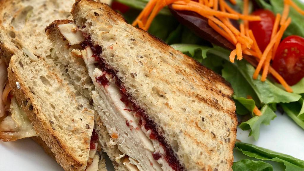 Turkey And Brie Sandy · Roast turkey, warm brie, cranberry compote, champagne mustard, toasted whole wheat.