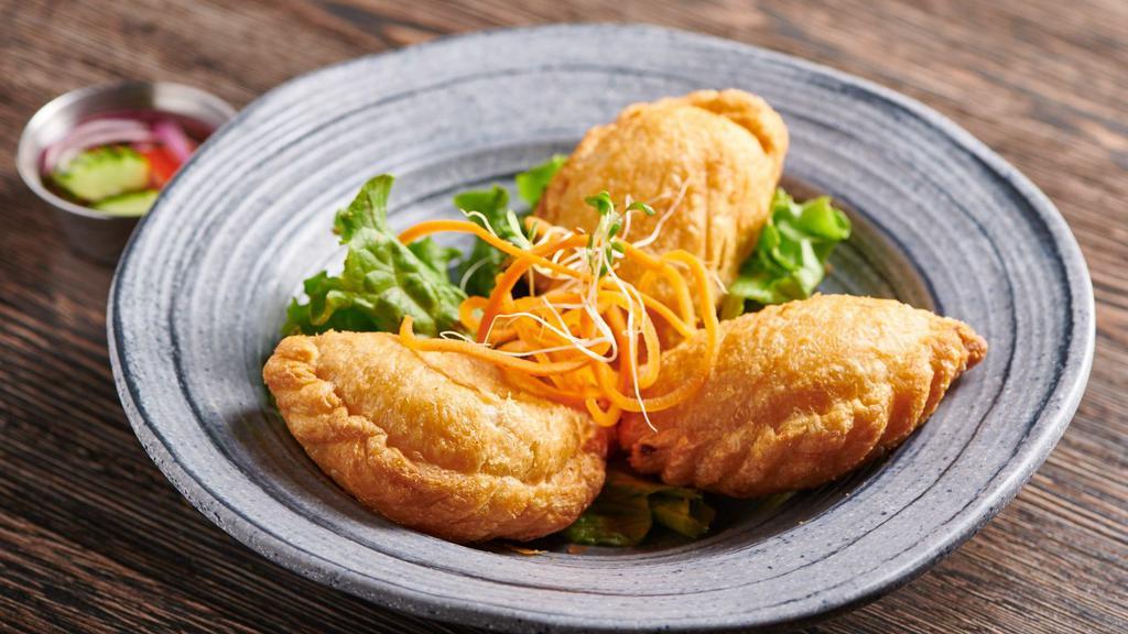 Kra-Pow Puff · Lightly deep-fried pastry puffs filled with minced chicken, string beans, cheese, and basil, served with cucumber sauce. Pow.