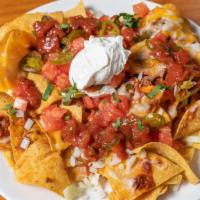 Nachos · Beef and bean chili, tortilla chips, jalapeño, tomatoes, onion, cheese, salsa, sour cream.