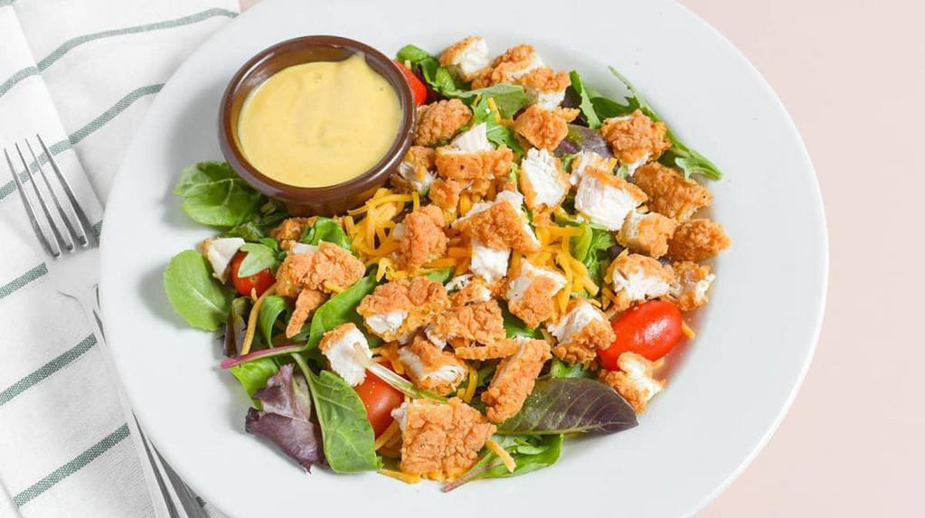 Crispy Chicken Salad · Spring greens, tomatoes, cheddar cheese and crispy chicken. Served with Honey Mustard