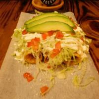 Flautas De Queso · Three crispy tacos filled with  Cheese topped with lettuce, tomato, Mexican cream, cotija ch...