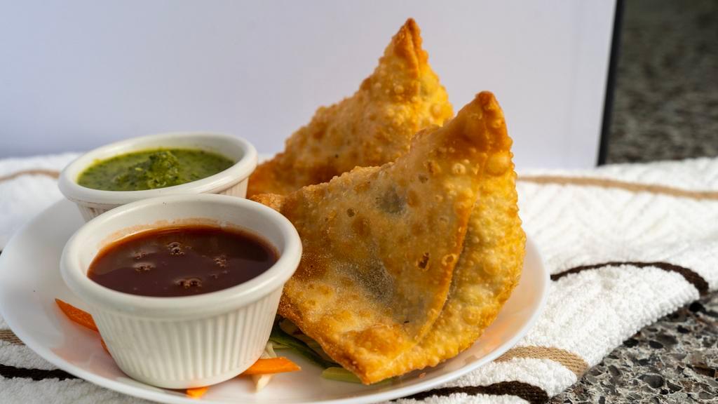 Vegetable Samosa · 2 pcs.  Golden crispy triangle pastry filled with mildly spiced potatoes and peas.