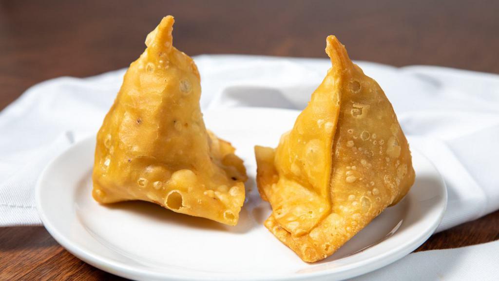 Vegetable Samosa · Crispy turnover, deliciously filled with mildly spiced potatoes, and green peas.