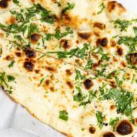 Garlic Naan · Teardrop shaped traditional Punjabi white bread, baked in the tandoor with garlic.
