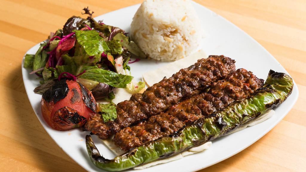 Lamb Adana Kebab · Ground lamb flavored with red bell peppers, slightly seasoned with paprika and grilled on skewers served salad and rice.