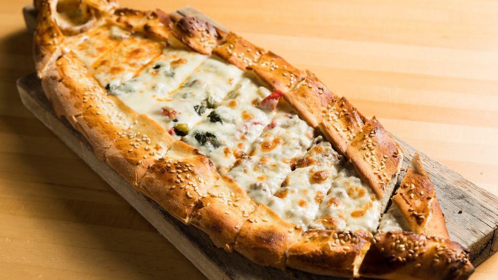 Karisik Pide (Mixed Pide) · A thick dough crust stuffed with seasoned ground lamb, kashar cheese, soujouk, spinach.