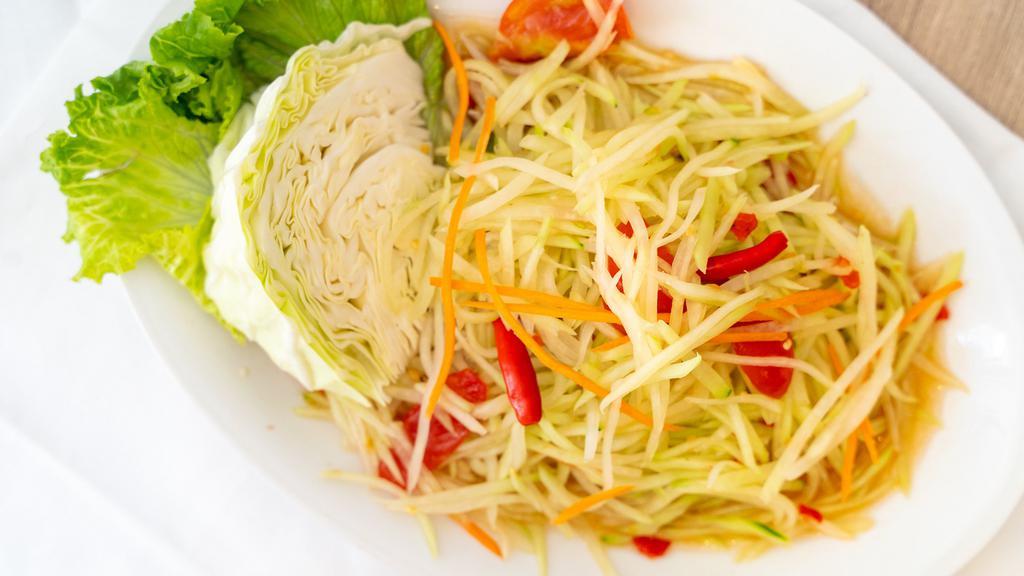 Green Papaya Salad · Som tum. Freshly shredded green papaya prepared with tomatoes, house tamarind sauce, and served with lettuce and cabbage.