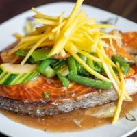 Salmon Steak With Fresh Mango · Grilled salmon steak served with special sauce top with fresh mango , steamed veggies and st...