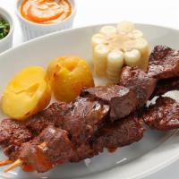 Anticuchos (3) · 3 skewered beef hearts marinated in tumi's special sauce served with potato and corn. / Tres...