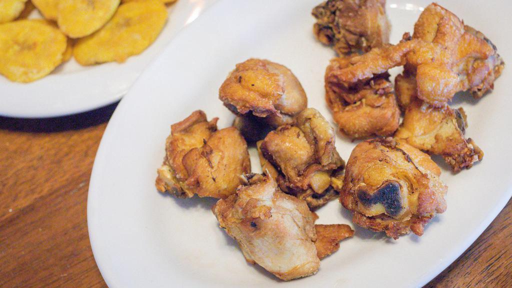 Chicharron De Pollo Con Longaniza Y Tostones · Fried Chicken pieces with Spanish sausage and fried Plantains.