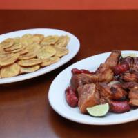 Chicharron De Puerco Con Tostone · Fried pieces of pork with fried plantains.