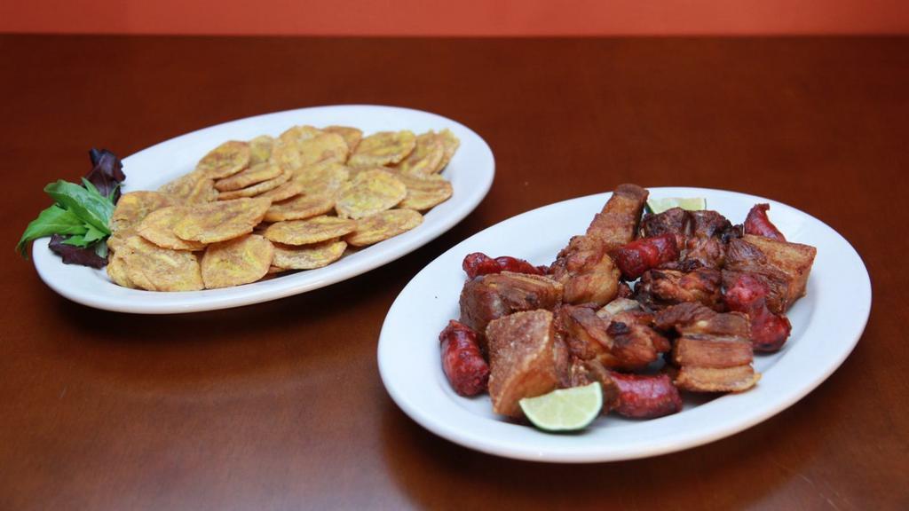 Chicharron De Puerco Con Longaniza Y Tostones · Fried pieces of Pork with Spanish Sausage and Fried Plantains.