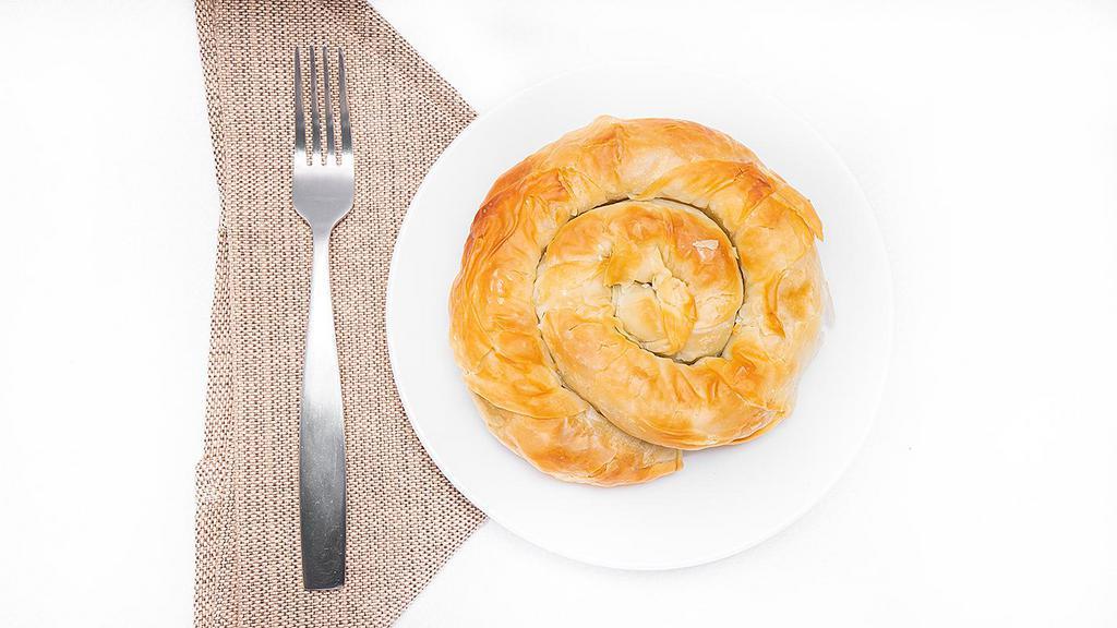 Spanakopita · Traditional Greek spinach pie with fresh herbs and aged feta cheese, wrapped in handmade phyllo dough.