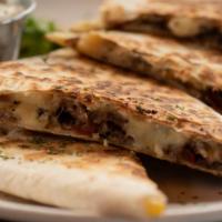 The Steak And Bacon Quesadilla · Quesadilla made with Steak, crispy bacon strips, melted cheese, green peppers, and red onions.