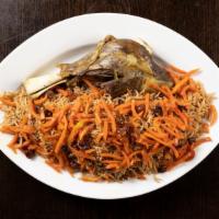 Qabuli Palow · Traditional afghan brown rice over lamb shank topped with raisins and carrots served with ga...