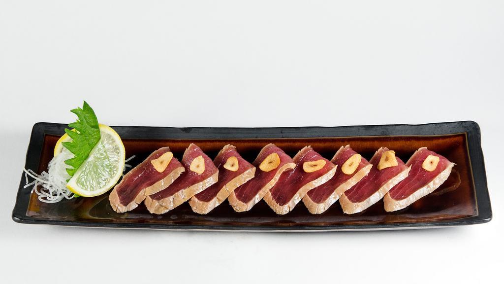 Maguro Zuke · Soy marinated tuna with garlic chip and onion sauce.