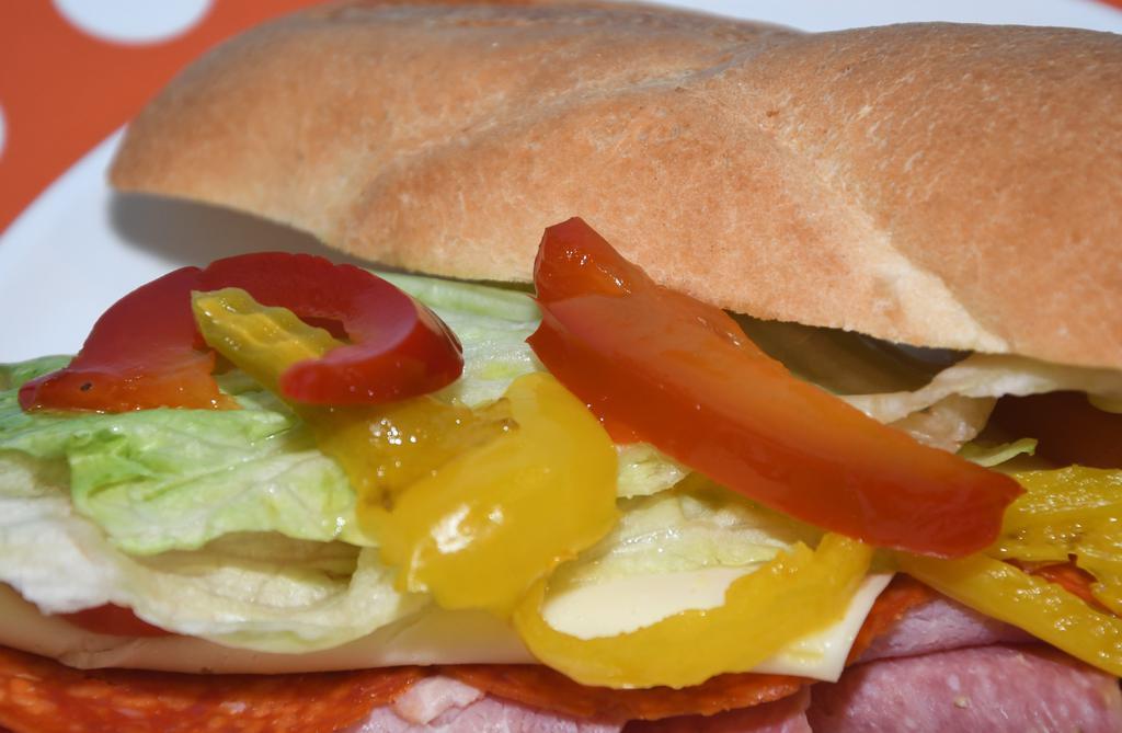 Italian Sandwich · Genoa salami, cappy ham, pepperoni, provolone, onion, lettuce, tomato sweet and hot peppers, and Italian dressing on a hero.