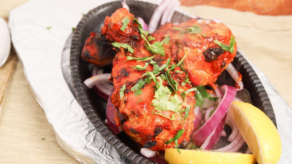 Tandoori Chicken Half · Chicken marinated in a mixture of dahi (yogurt) and tandoori masala a spice blend. it is seasoned and colored with cayenne pepper red chili powder as well as turmeric or food coloring.