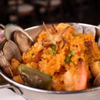 Paella Matíz · Saffron rice mixed with mussels, clams, shrimp, calamari, scallops, green peas, Spanish chor...