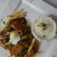 Lomo Saltado · Stir-fried sirloin strips, onions, tomatoes, bell peppers, served over french fries and whit...