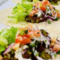 Falafel Wrap ( Veggie) · It served with Falafel , home made salad, tahini sauce or Garlic Sauce … white Sauce is reco...