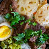 Slow-Braised Beef Bian Dang · Tender beef braised in traditional spices. Served over rice w/ shredded mustard greens, soy ...