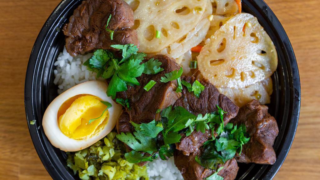 Slow-Braised Beef Bian Dang · Tender beef braised in traditional spices. Served over rice w/ shredded mustard greens, soy egg & one side. Garnished w/ cilantro.